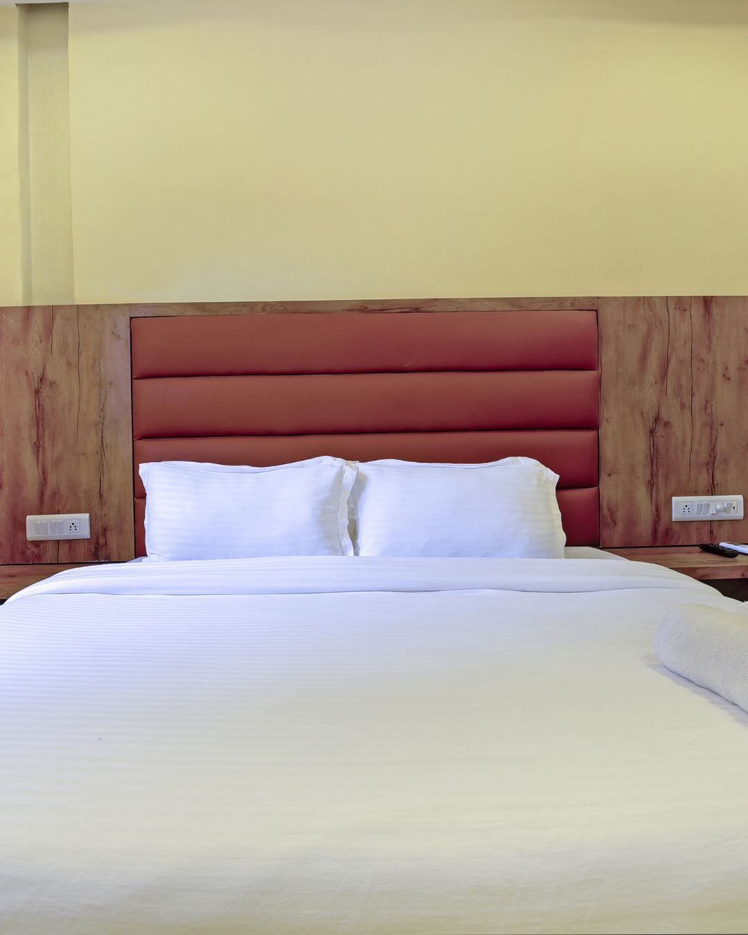 Comfortable bed with fresh linens and padded headboard